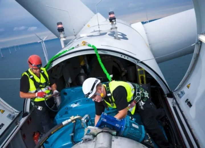 Two technicians working inside a wind turbine